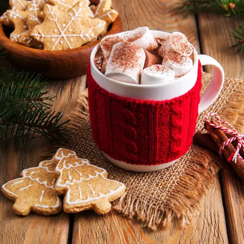 Red knit-covered mug filled with hot chocolate and marshmallows for staying active during the holiday season.